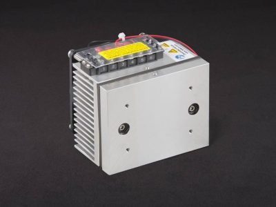 Three-quarter view of thermoelectric cold plate cooler/heater. Cooled aluminum plate on the front, waste heat exhausted to fins on back. Fins are fan cooled. The fan air enters on the middle back and exhausts on sides. Operates on 12 volts DC and removes 30 watts of heat at a 0°C temperature difference relative to ambient.