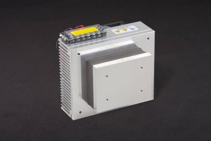 Three-quarter view of thermoelectric cold plate cooler/heater. Cooled aluminum plate on the front, waste heat is exhausted to fins on back. Fins are fan cooled. The fan air enters on the middle back and exhausts on sides. Operates on 12 volts DC and removes 32 watts of heat at a 0°C temperature difference relative to ambient. An internal extender block improves the heat pumping capacity at larger temperature differences.