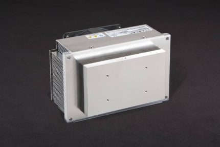 Three-quarter view of thermoelectric cold plate cooler/heater incorporating two large thermoelectric modules. Cooled aluminum plate on the front, waste heat is exhausted to fins on back. High density fins are fan cooled. The fan air enters on the middle back and exhausts on sides. Operates on 24 volts DC and removes 105 watts of heat at a 0°C temperature difference relative to ambient. Internal extender blocks improve the heat pumping capacity at larger temperature differences.